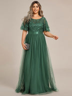 Eucalyptus green plus size gown with a sequinned leaf bodice, satin waistband and tulle skirt.