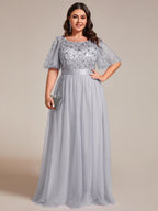 Plus size gown with a sequinned leaf bodice, satin waistband and full tulle skirt.
