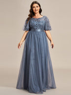 Plus size gown with a sequinned leaf bodice, satin waistband and full tulle skirt.