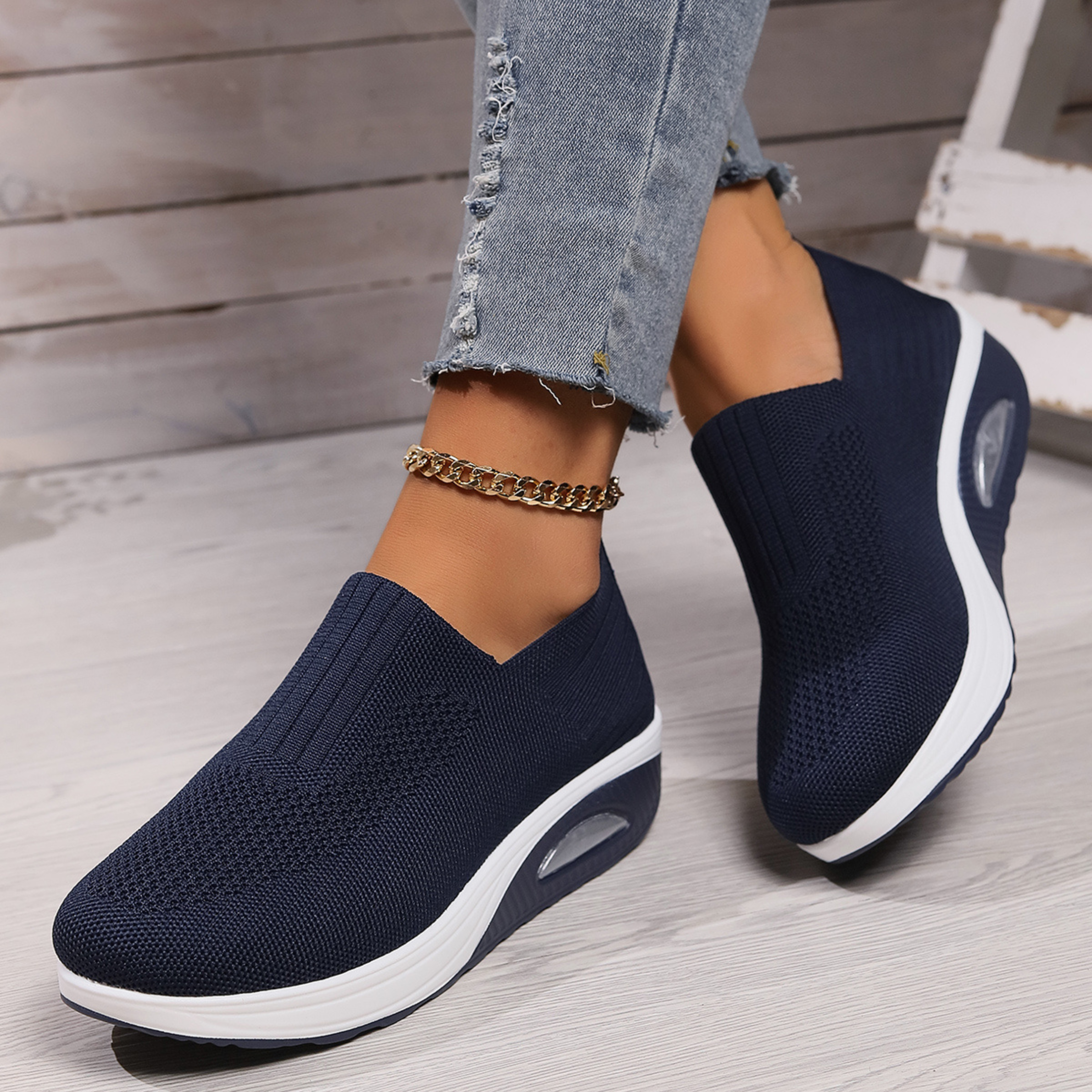 Navy knitted orthopedic slip-on sneakers for women with a cushioned wedge sole.