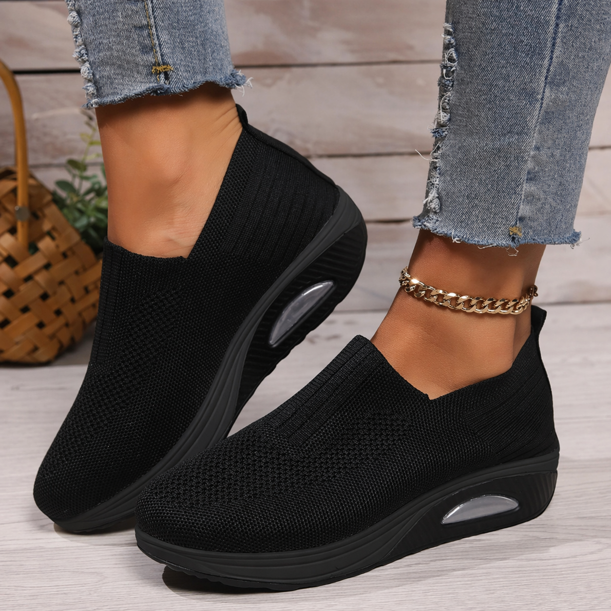 Black knitted slip-on sneakers for women with a cushioned wedge sole.
