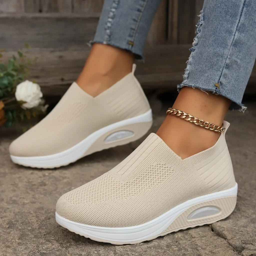 Knitted slip-on sneakers for women with a cushioned wedge sole.