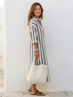 A striped midi shirt dress in navy blue with buttons down the front and long sleeves. 1