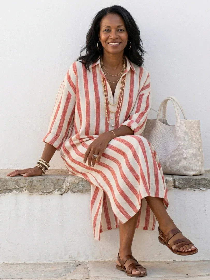 A striped midi shirt dress in navy blue with buttons down the front and long sleeves. 5
