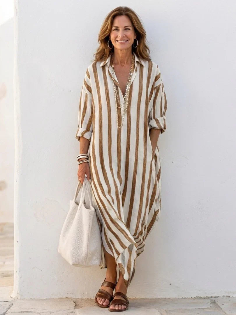 A striped midi shirt dress in navy blue with buttons down the front and long sleeves. 6