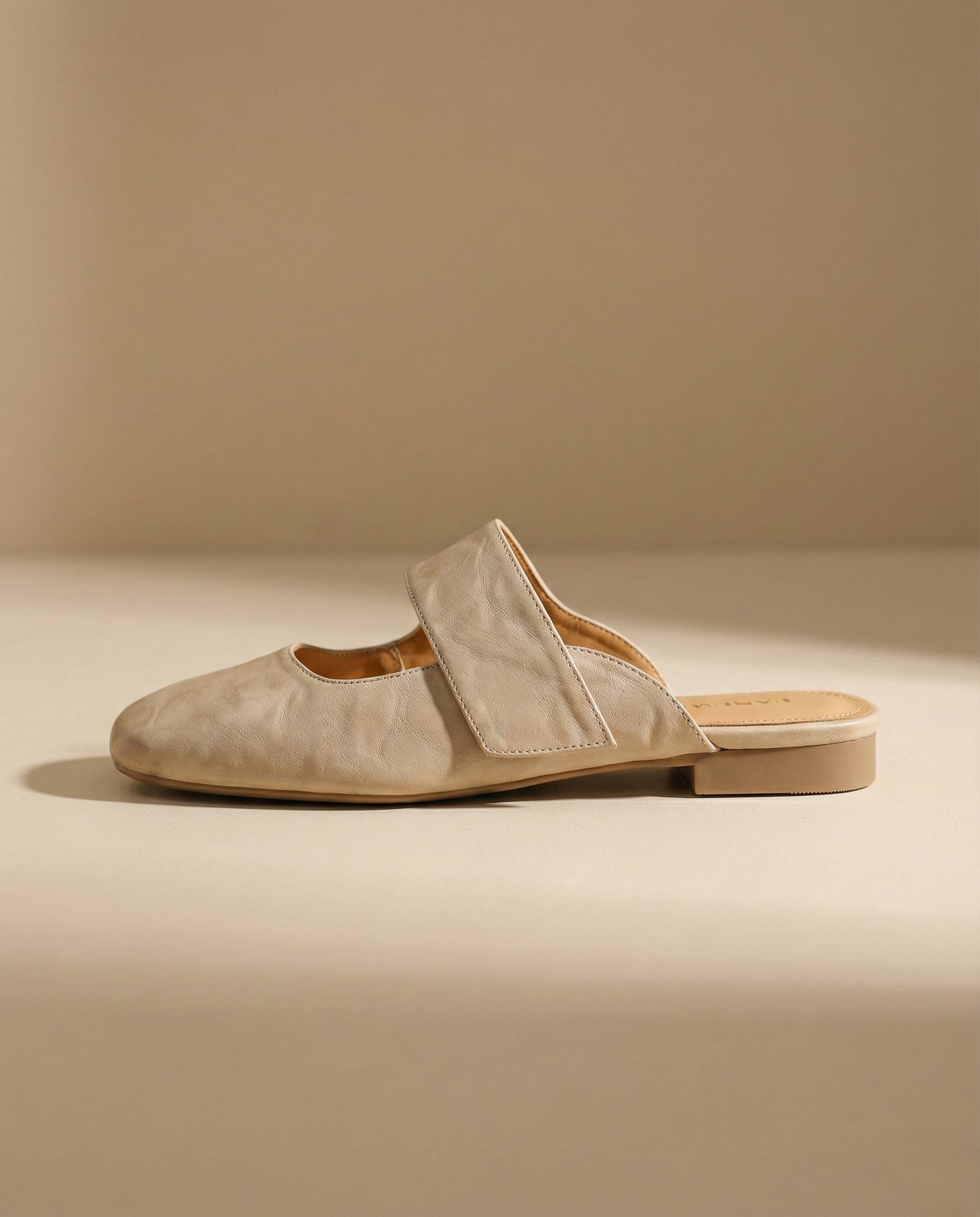 Tan chunky heel mules with a modern, minimalist design, perfect for casual or dressy occasions. 2