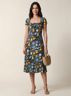 Black floral tulip print midi dress, full body view with basket bag