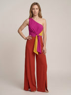 Asymmetric one-shoulder magenta jumpsuit with tie belt and wide-leg trousers, front view